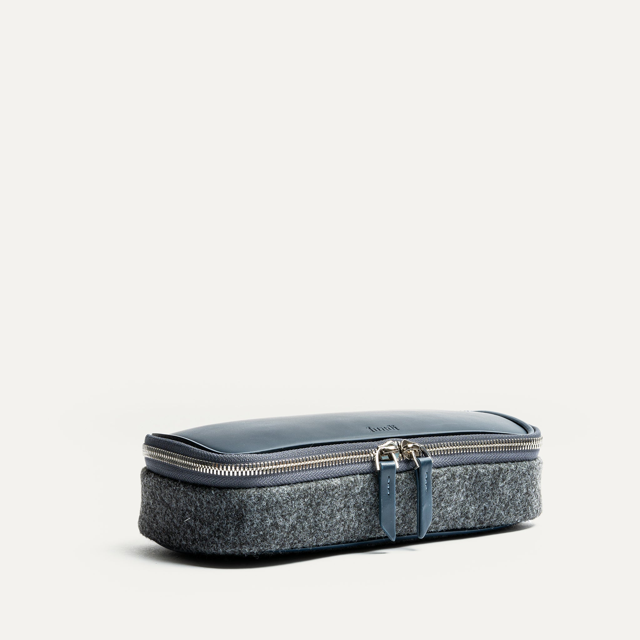 Trousse de toilette homme cuir en feutre gris et cuir bleu, élégante et fermée avec double fermeture éclair.