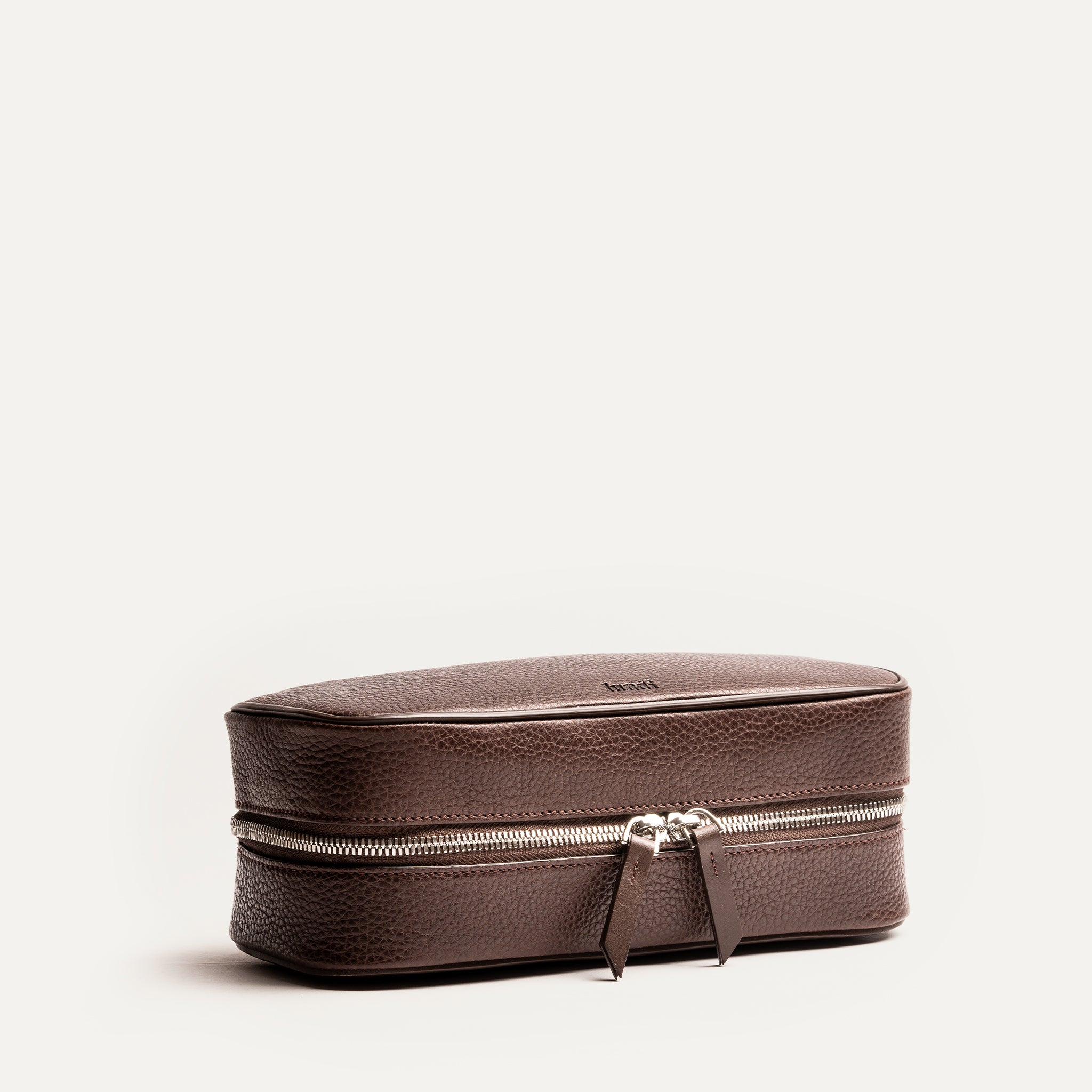 Trousse de toilette homme cuir marron fermée, élégante et raffinée, idéale pour les déplacements.