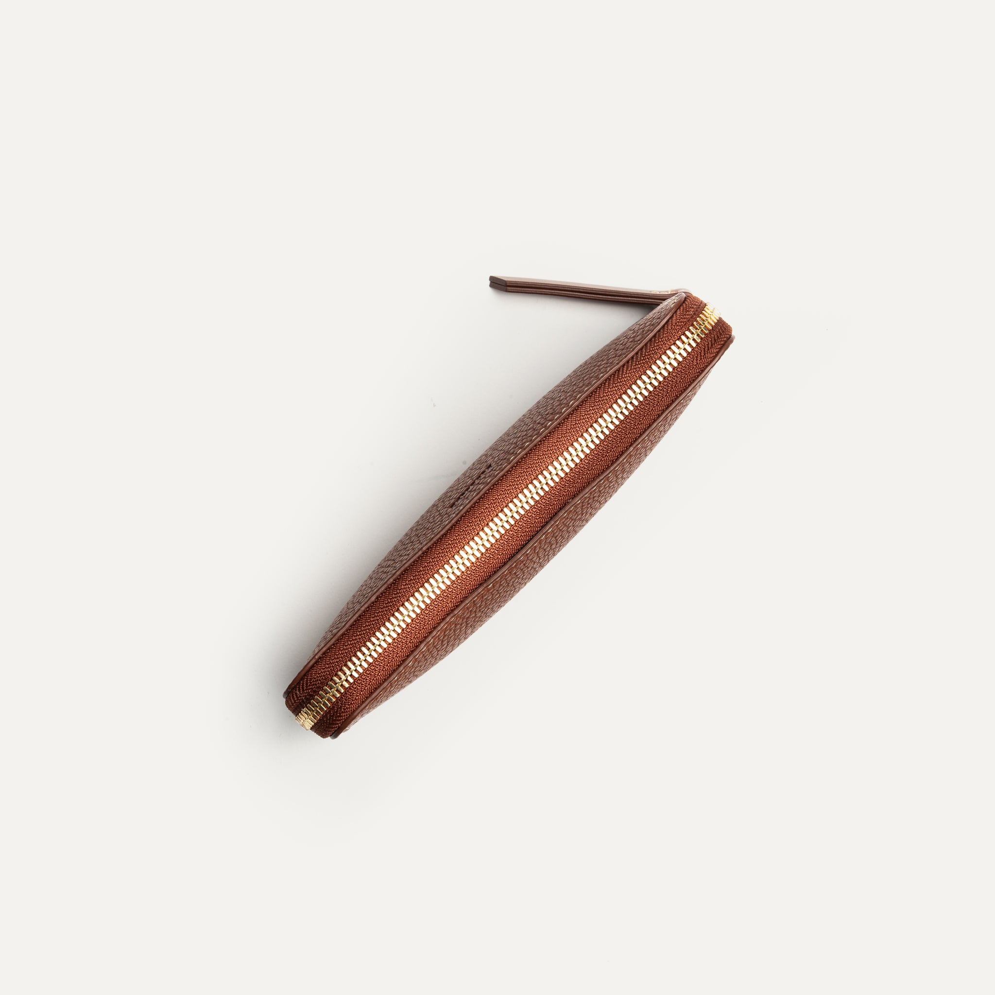 Longue poche zippée sur un compagnon en cuir grainé cognac