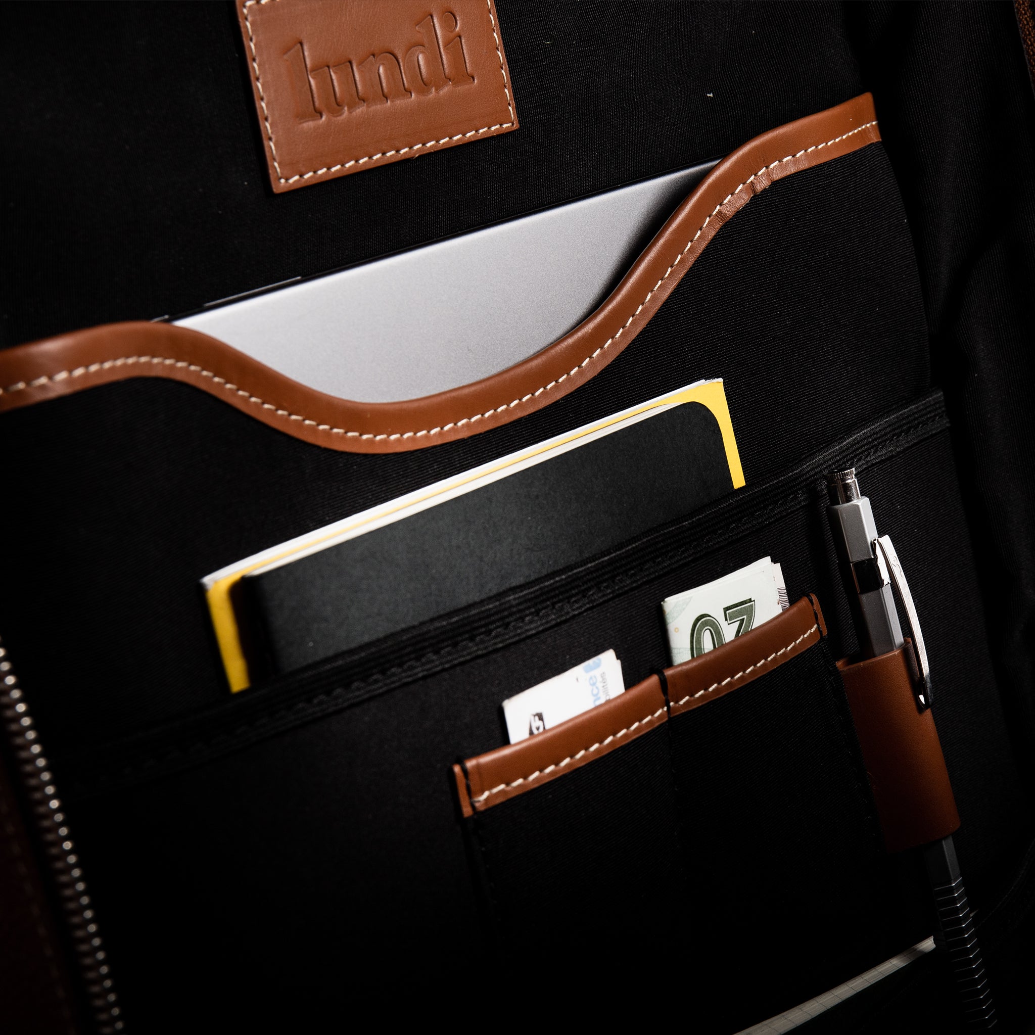 L'intérieur du sac à dos homme Giani en cuir grainé, proposant des poches protectrices pour ordinateur portable.