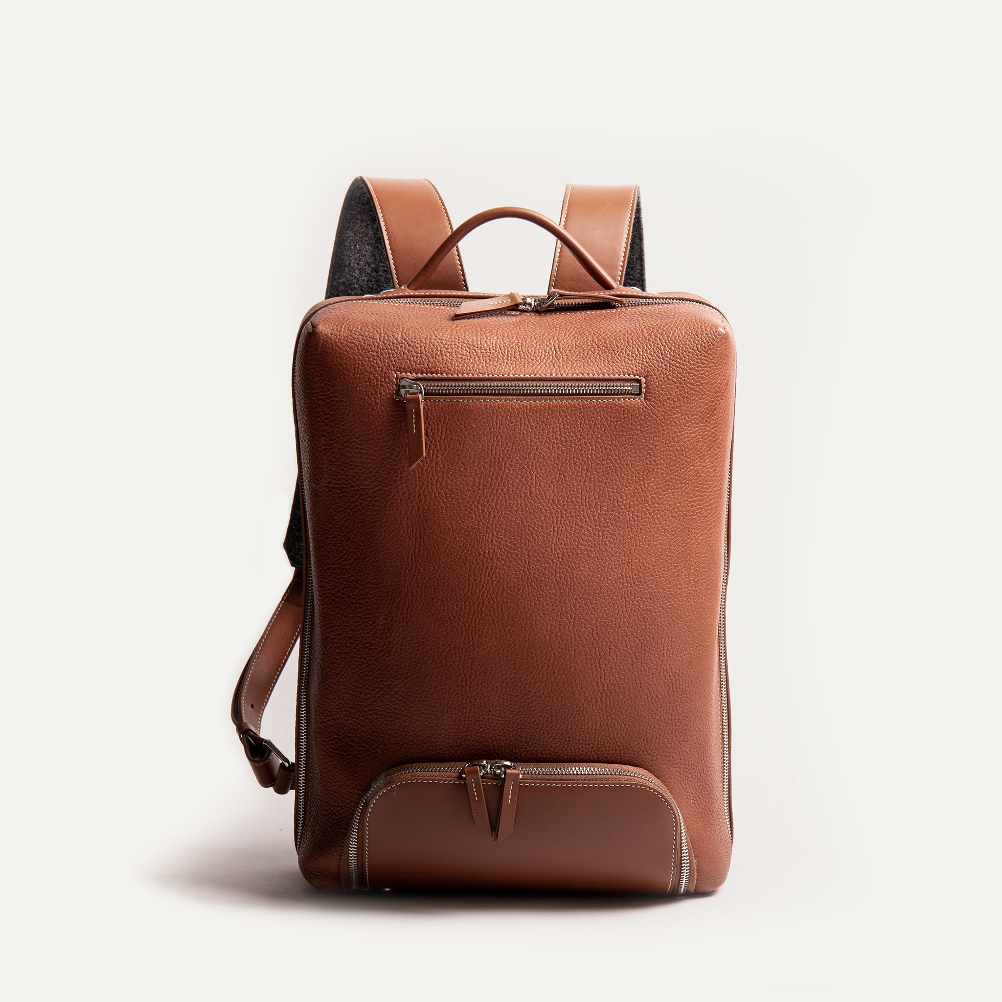 Le sac à dos Giani en cuir grainé pour homme propose un format compact et une poche avant pour ranger ses câbles et autres accessoires de bureau.